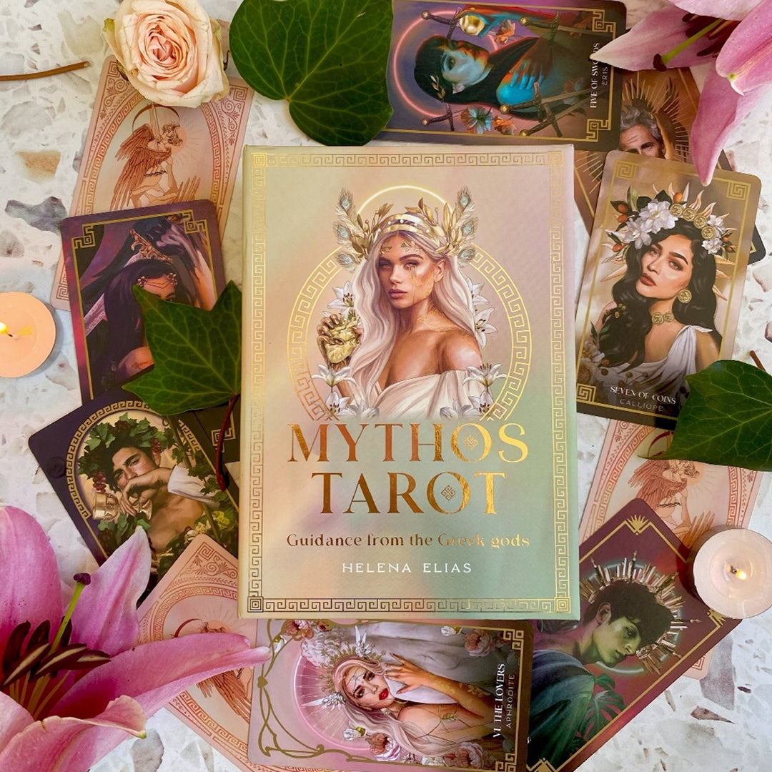 A collection of tarot cards spread around a gold box. Each card depicts a Greek God or Goddess. On the box is golden text saying "mythos tarot: guidance from the greek gods." An image of a blonde greek goddess wearing a golden crown sits above the text.