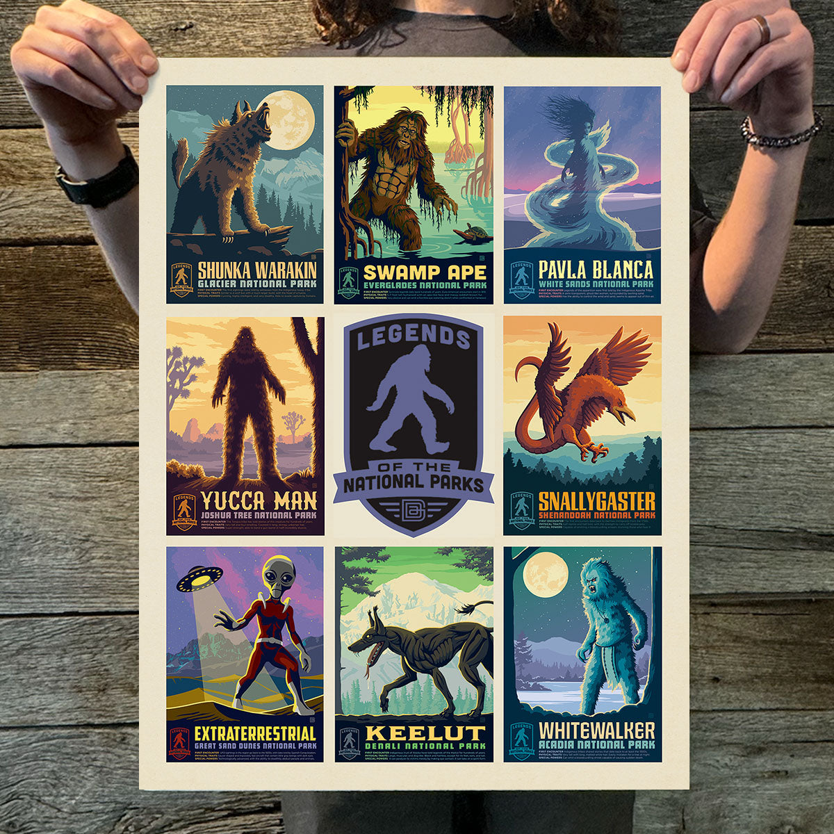 Person holding a poster with various illustrated characters against a wooden background