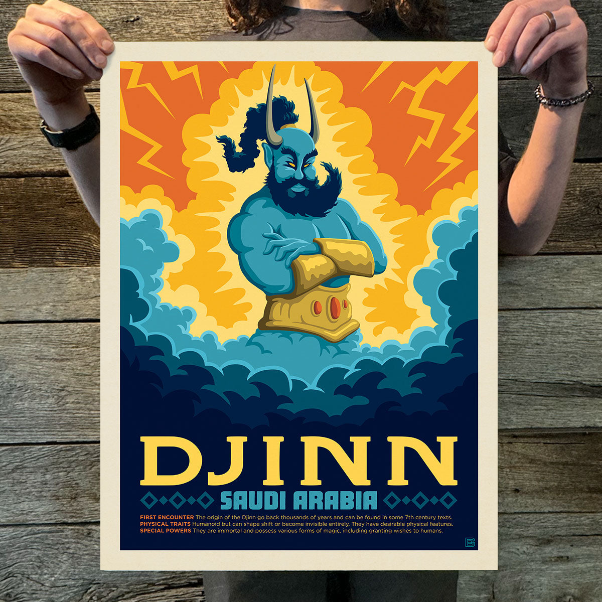 Person holding a poster of a djinn with vibrant colors on a wooden surface