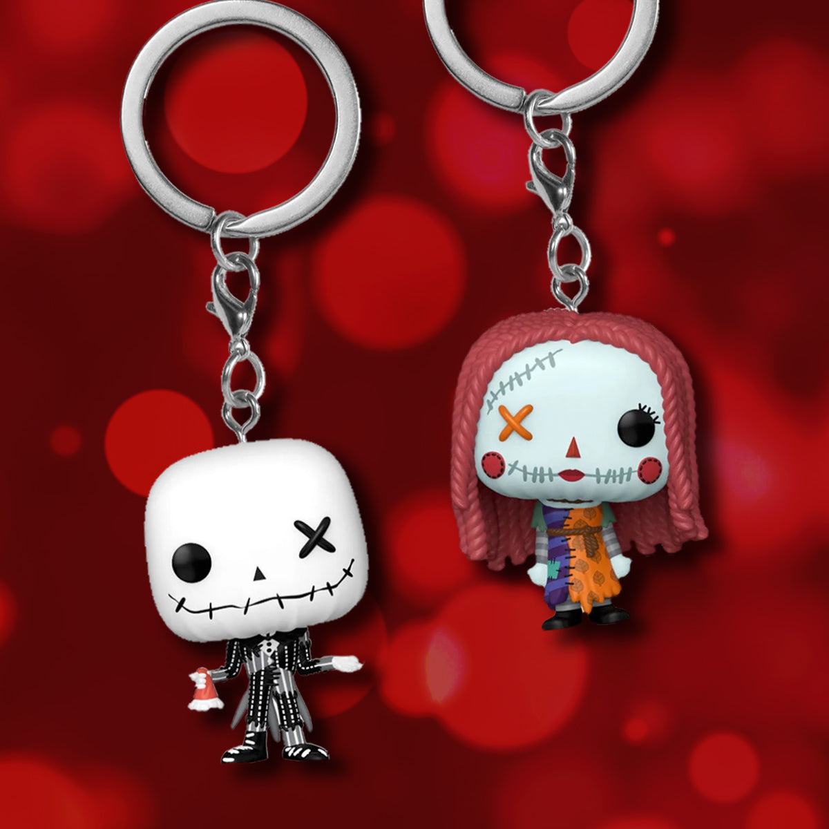 Two keychains depicting Jack and Sally from Nightmare Before Christmas 
on a red background