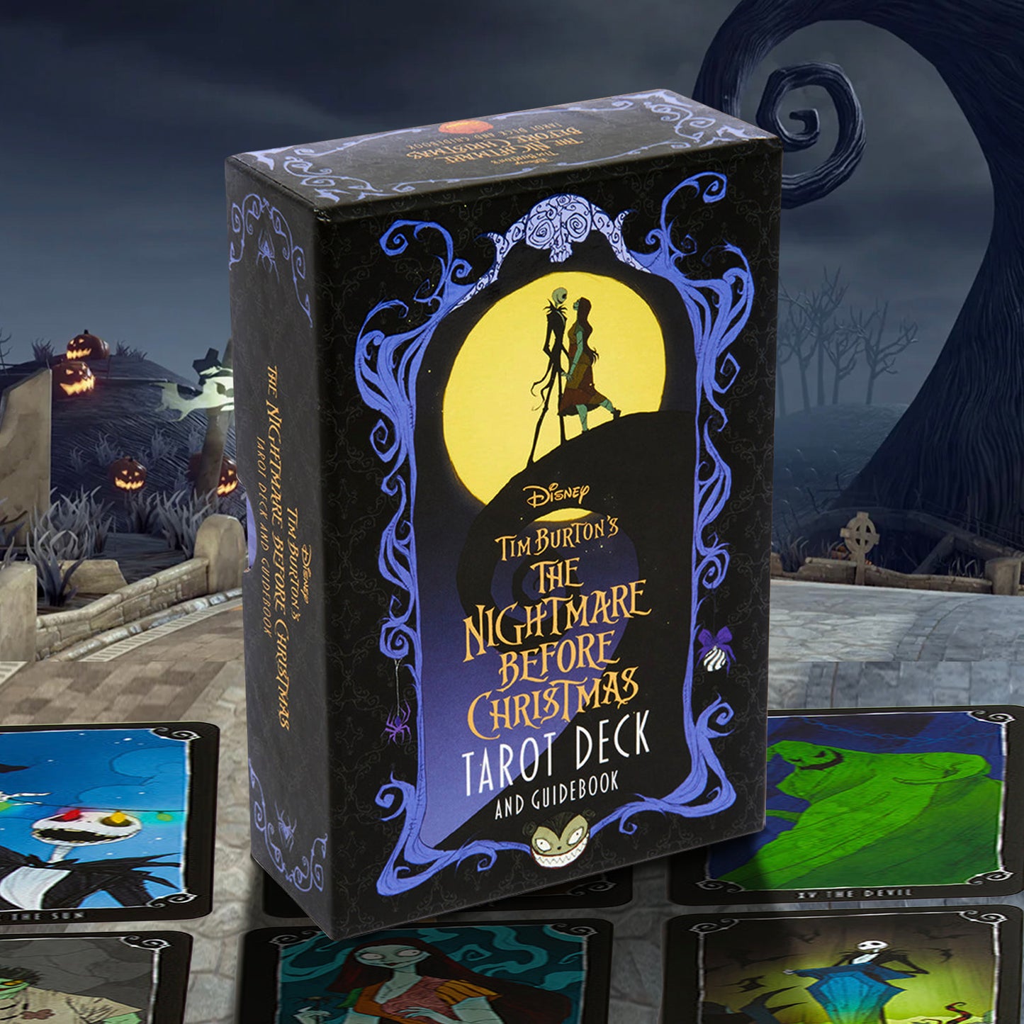The Nightmare Before Christmas Tarot Deck and Guidedbook box standing upright, surrounded by sample tarot cards on a stone surface with a dark Halloween-themed outdoor scene in the background. Visible Disney branding appears on the box front.