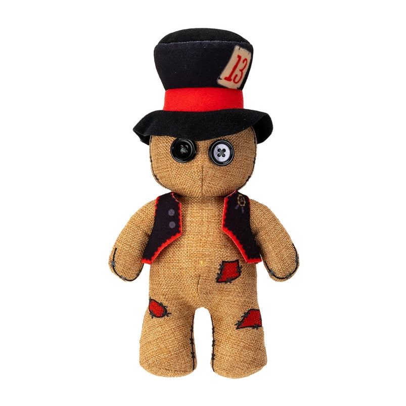 A stuffed plushie on a wooden table, against a white background. The plushie has a black and red top hat and vest, with black buttons as eyes. A patch on its hat has the number 13 in red.