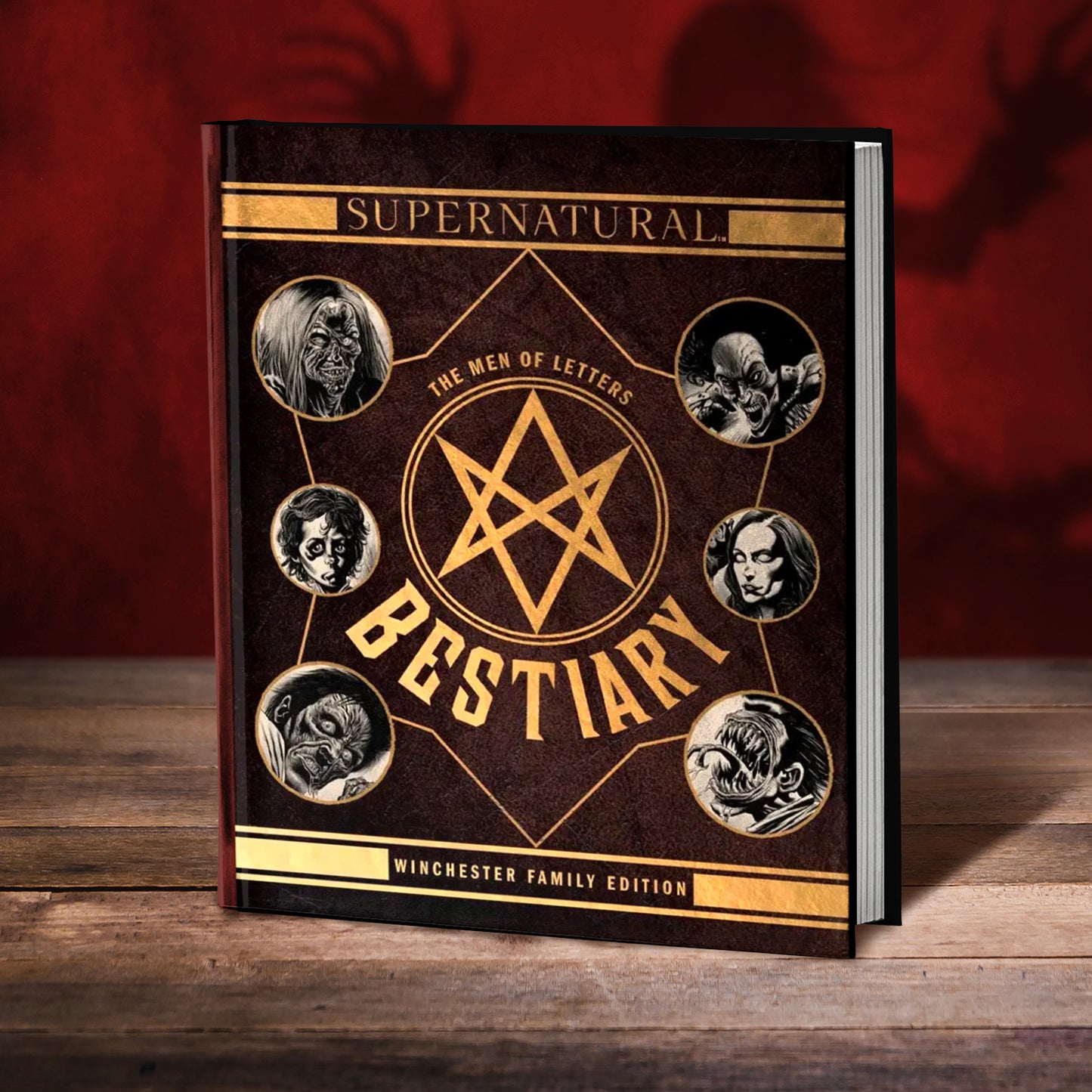 Supernatural Bestiary book with Winchester family edition design on a wooden surface.