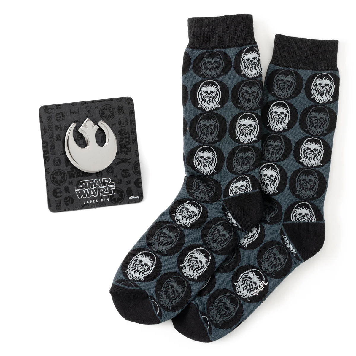 Black and grey socks with white Chewbacca pattern on a white background. Next to the socks is a Rebel Alliance lapel pin