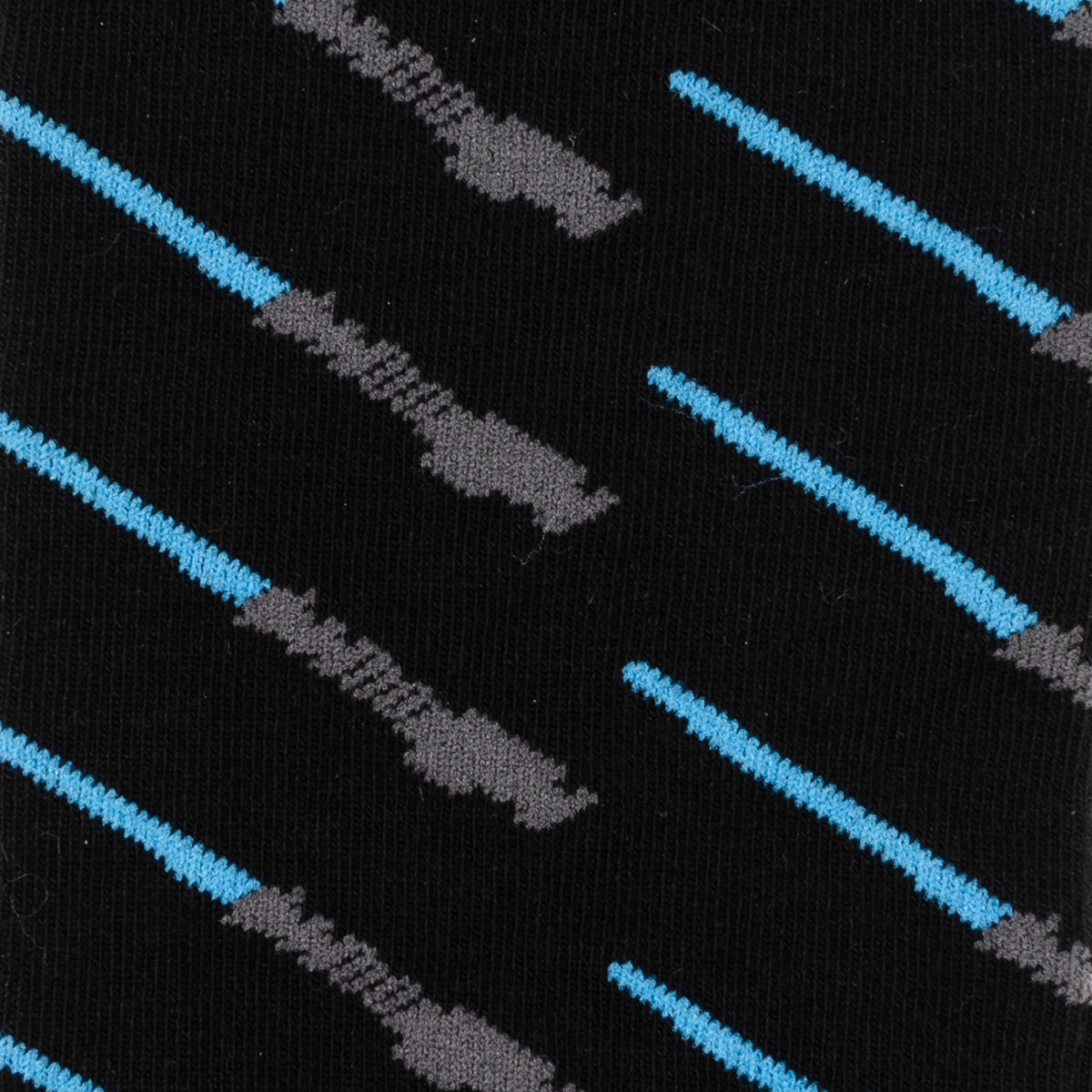 Close up of a black sock  with a repeating blue lightsaber pattern on a white background.