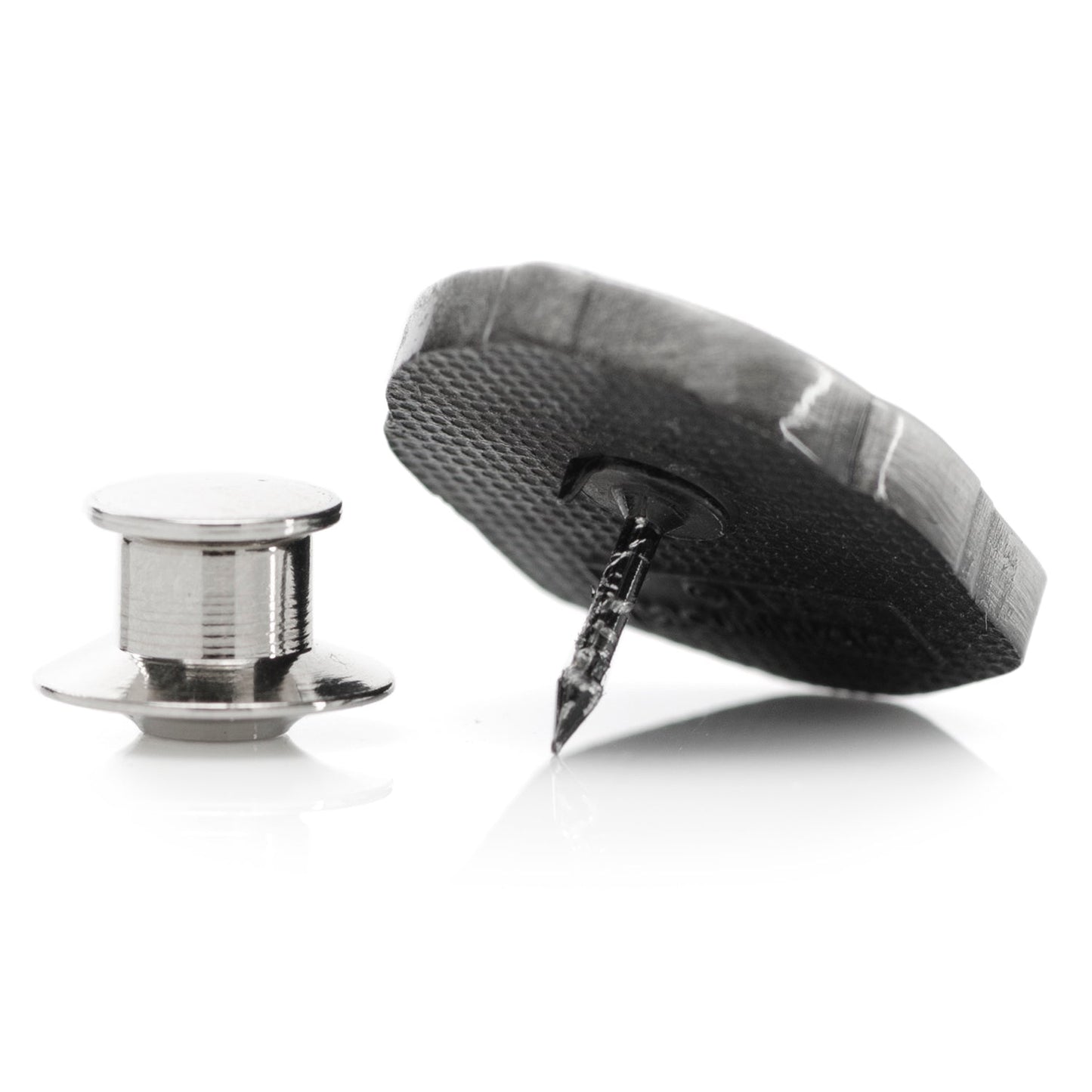 A black and silver lapel pin depicting a Mandalorian helmet