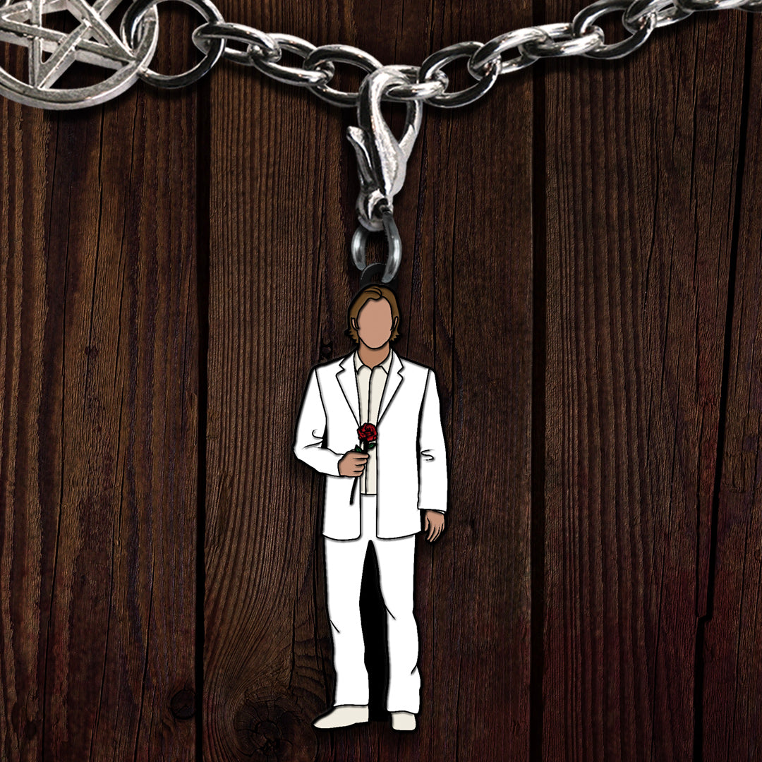 A metal charm on a bracelet, depicting the Supernatural character Sam in a white suit, holding a rose