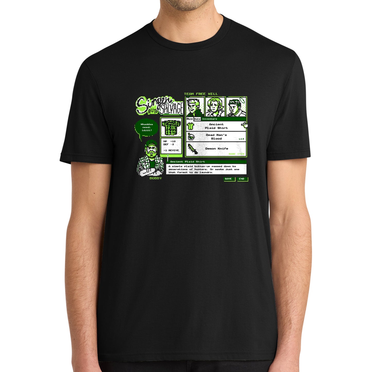 A man wearing a black short-sleeve t-shirt with a green and white retro video game-style graphic on the chest featuring cartoon characters and text.