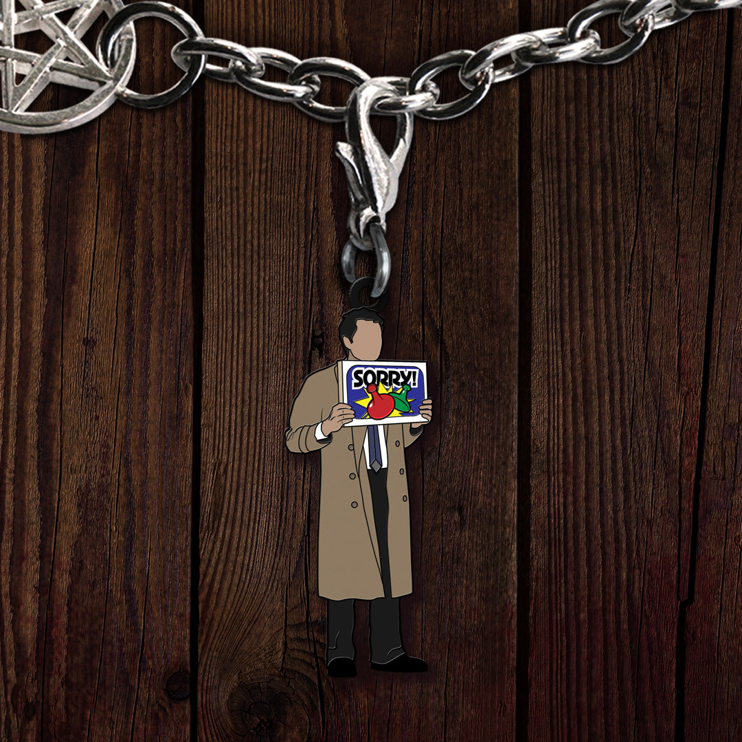 A metal charm on a bracelet, depicting the Supernatural character Castiel in a trench coat, holding up a "Sorry!" board game box