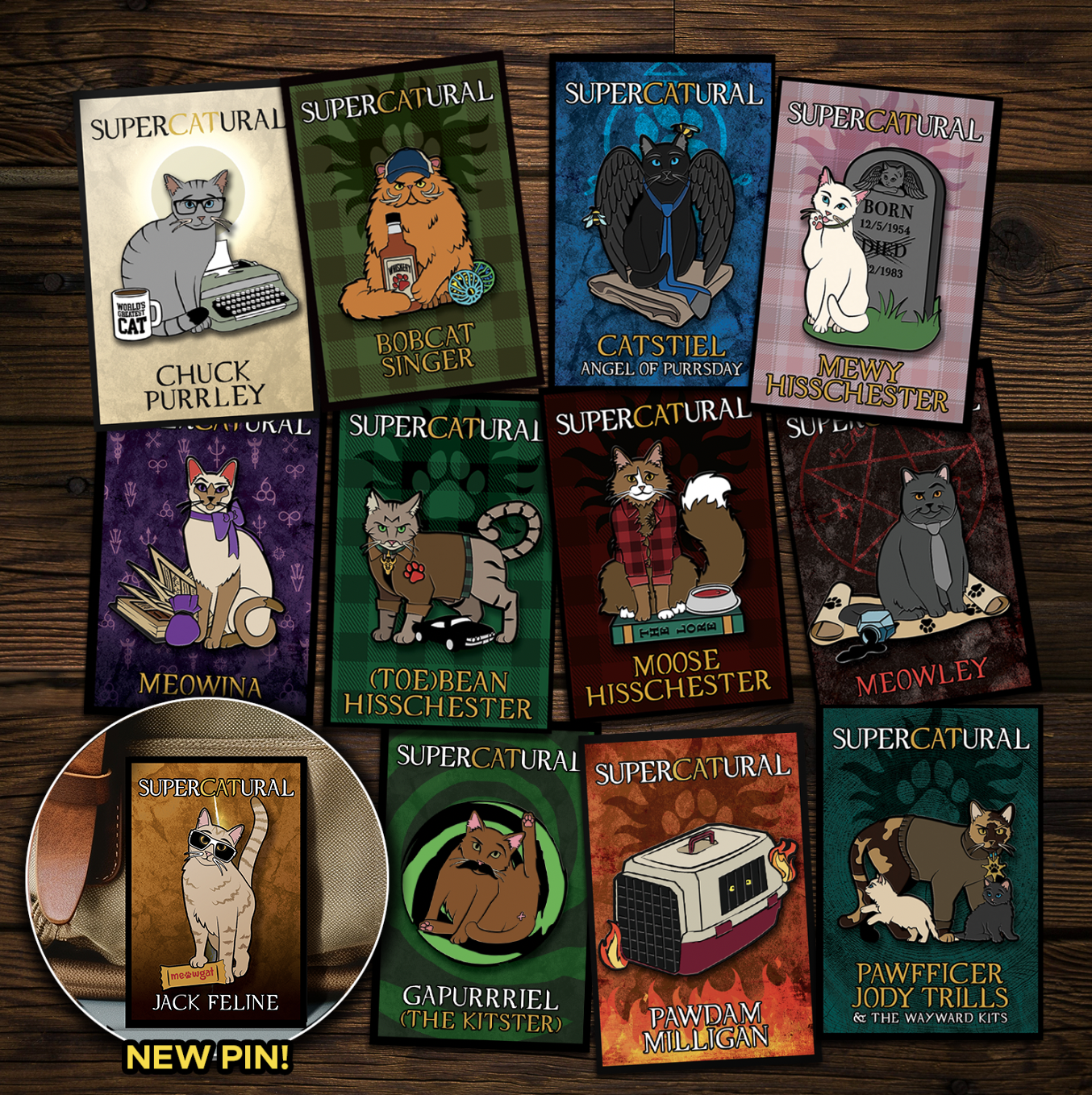 A collection of enamel pins on a wooden table. Each pin depicts a character from the TV series "Supernatural" reimagined as cats. An inset in the bottom left corner reads "NEW PIN!" and has an image of Jack Feline, the newest pin.