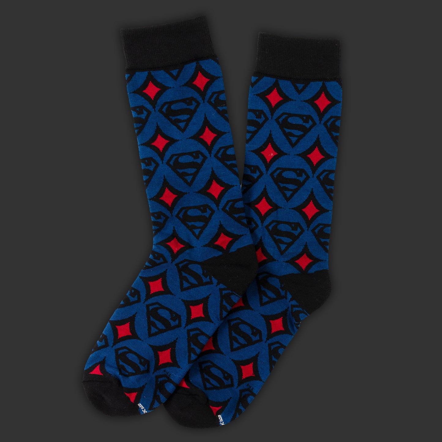 Superman-themed sock with blue, red, and black design on a dark background