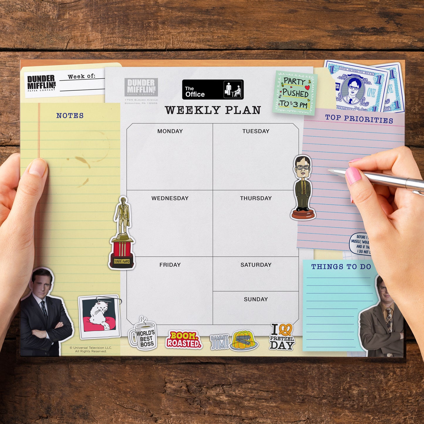Weekly planner with 'The Office' themed stickers on a wooden surface