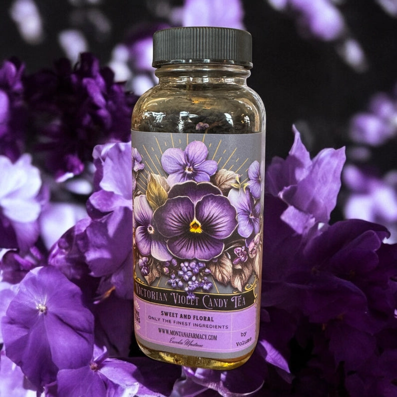 Bottle of Victorian Violet Candy Tea surrounded by purple flowers