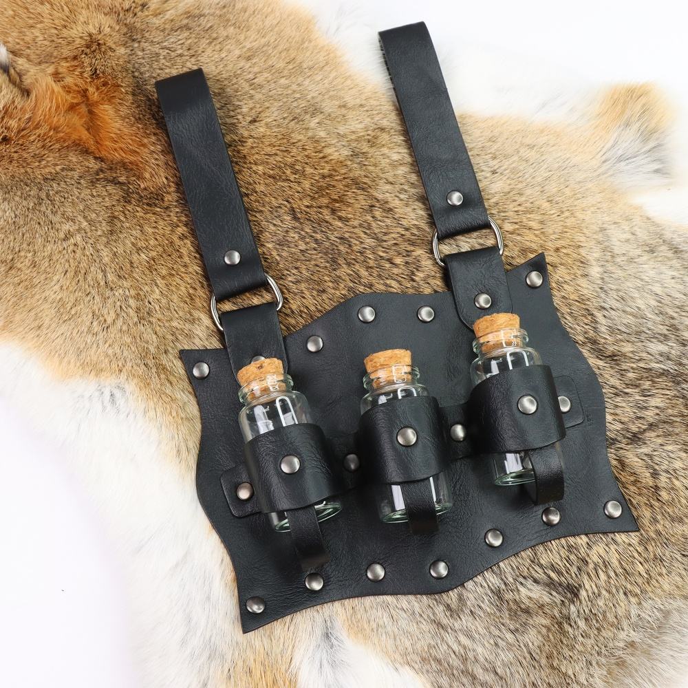A black, leathery belt pack, with three glass bottles held in place with straps. The pack has two belt loops at the top. Behind the pack is a furry rug.