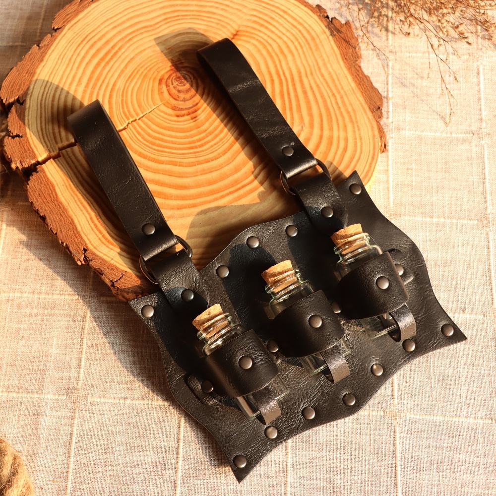 A black, leathery belt pack, with three glass bottles held in place with straps. The pack has two belt loops at the top. Behind the pack is a round plate made from a tree trunk.