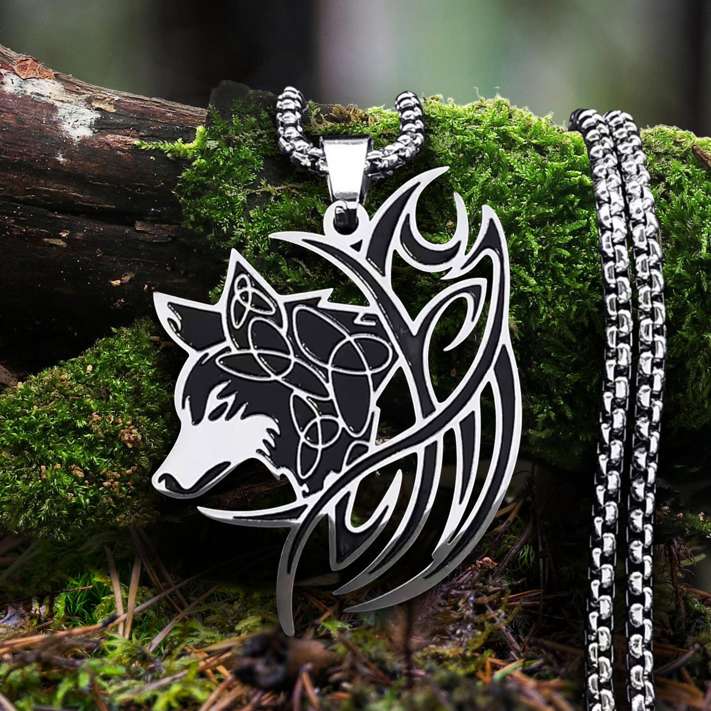 A silver necklace in the shape of a sideways-facing wolf's head with a swirling Norse-inspired design. The charm is on a silver chain.  