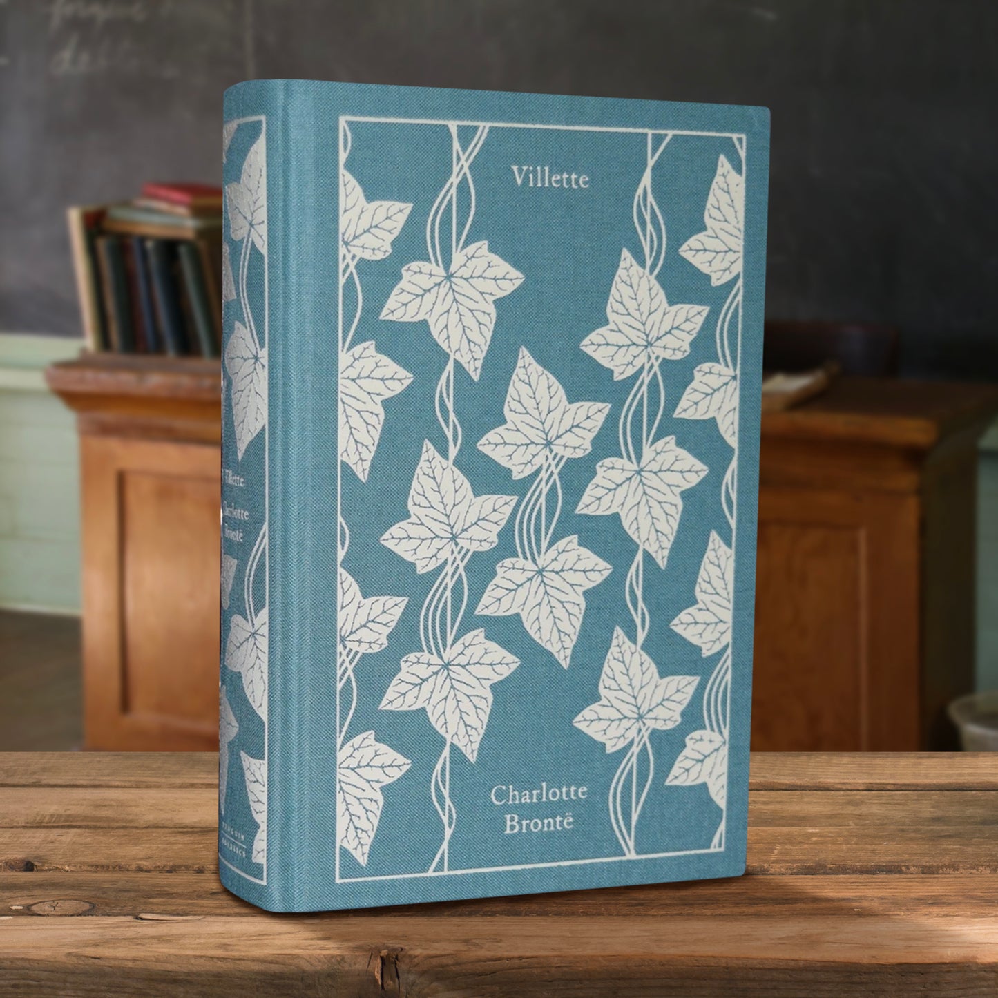 Blue book with white leaf pattern on a wooden surface