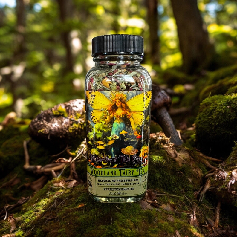 Bottle of Woodland Fairy Tea on a forest floor with a butterfly illustration on the label.