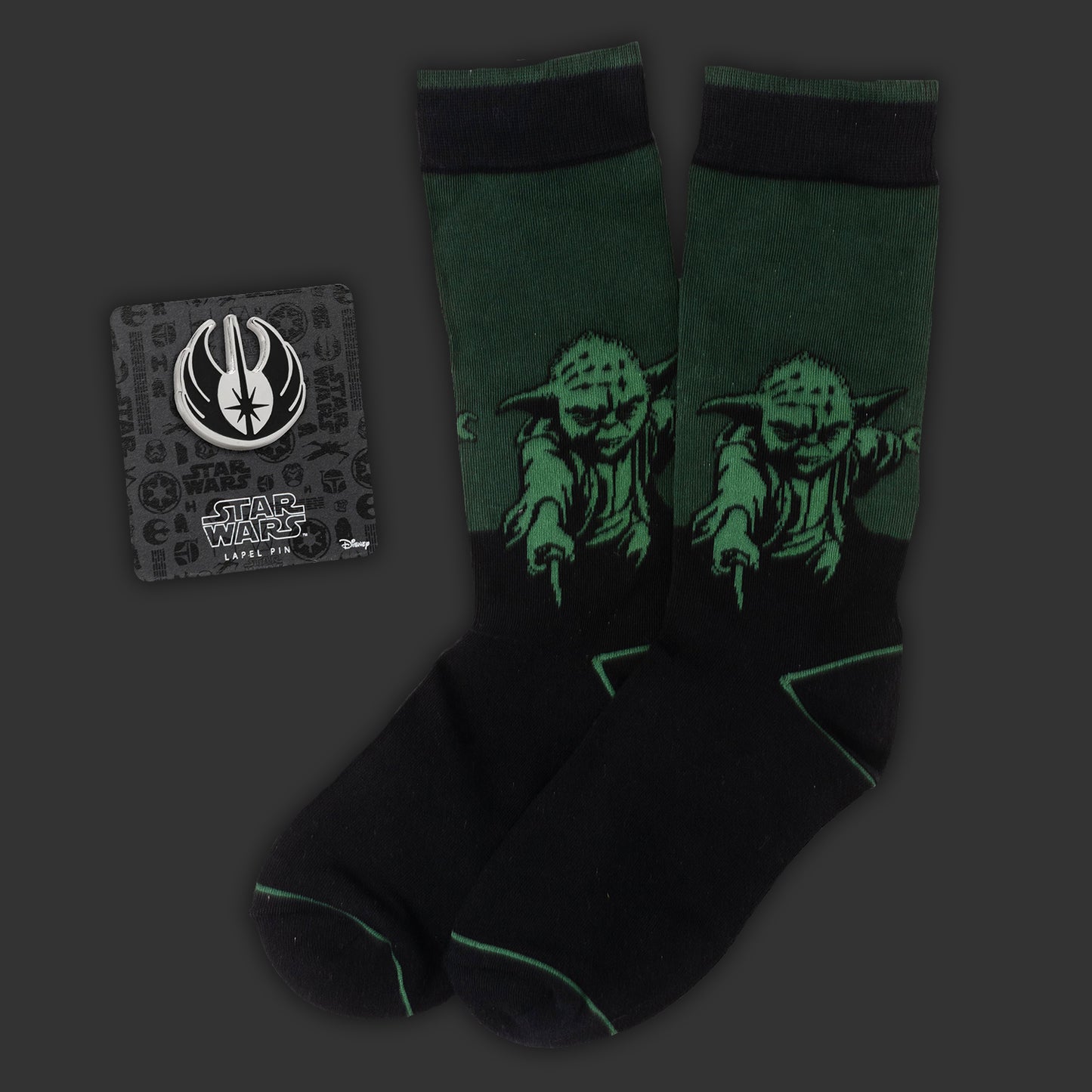 Black socks with Yoda design and Star Wars logo card on dark background