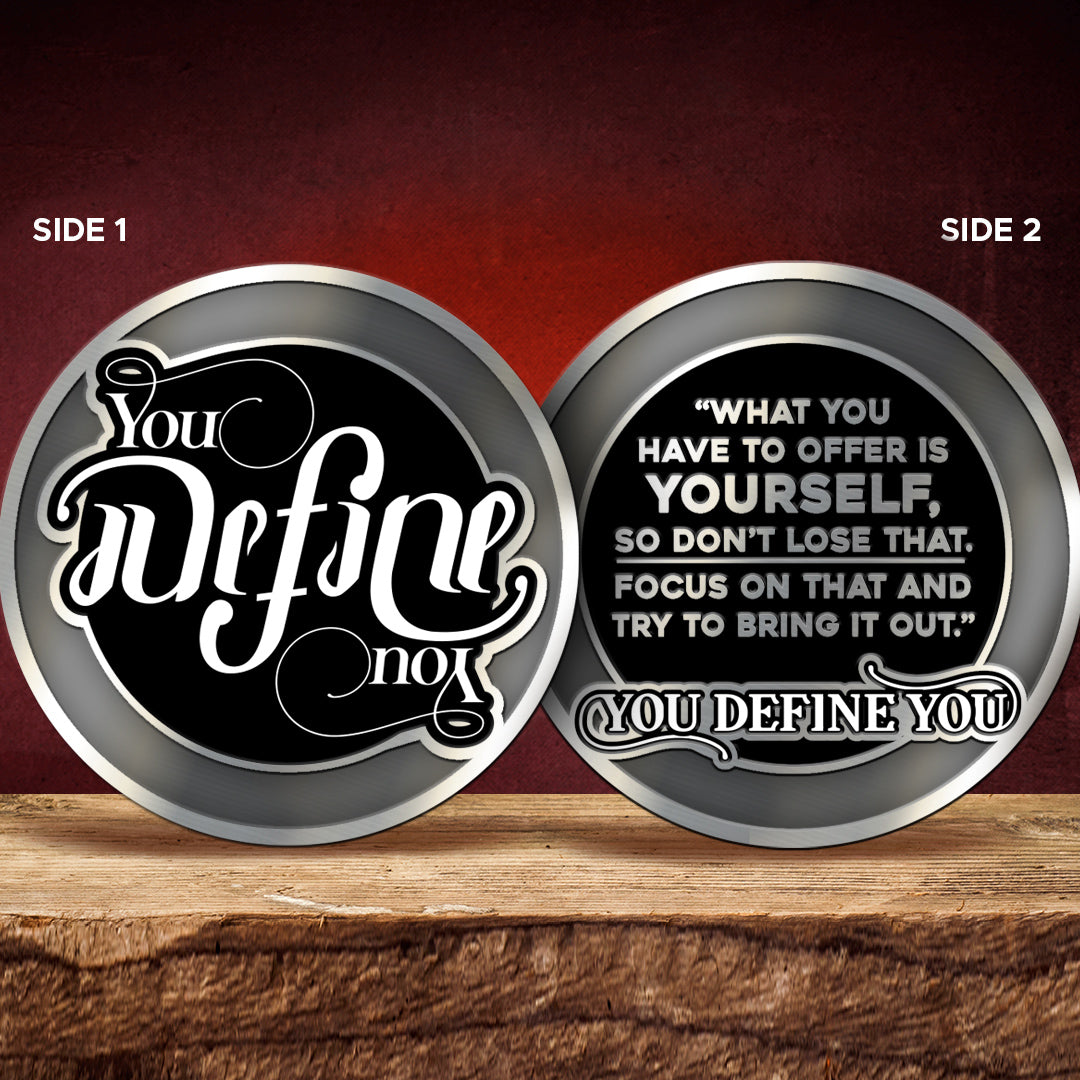 Two circular metal coins with motivational text on a wooden surface and red background