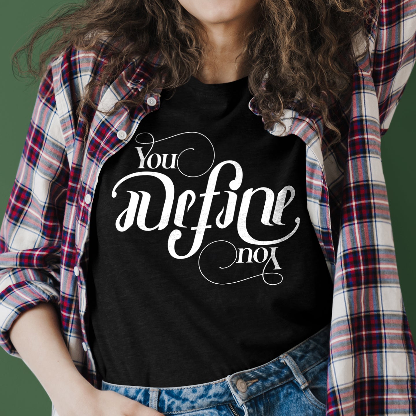 Person wearing a black t-shirt with white text and a plaid shirt.