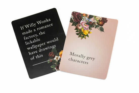 Two cards from the set against a white background. The left card is black with white text saying "if willy wonka made a romance factory, the lickable wallpaper would have drawings of this." The right card is pink with black text saying "morally grey characters.