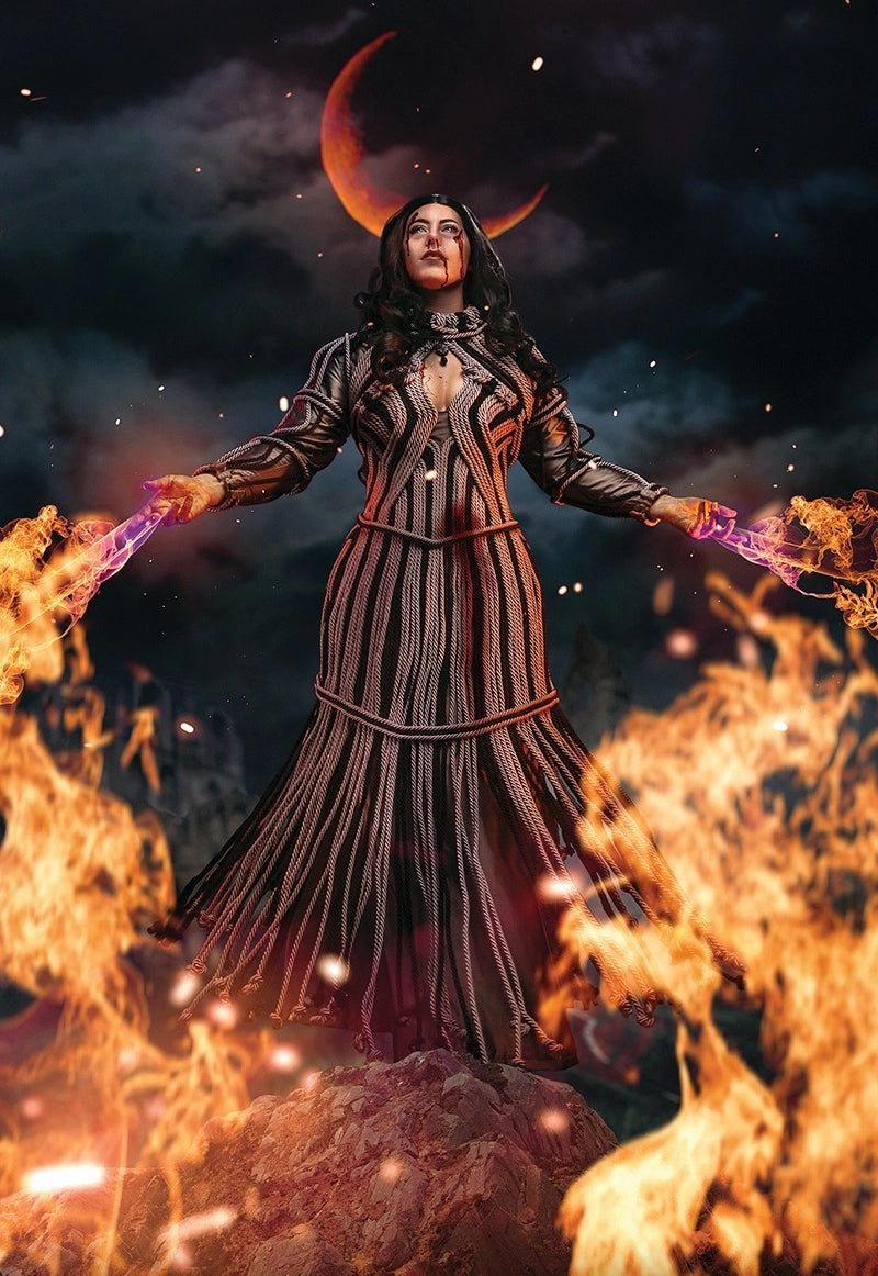 A cosplayer in a structured and fitted dress that appears to be made of neutral and black lengths of woven rope. They are edited to be creating fire with their hands in front of a dark sky.