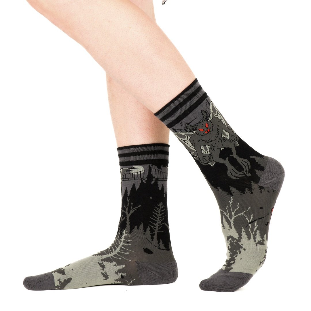 Gray and black patterned socks worn by a person on a white background