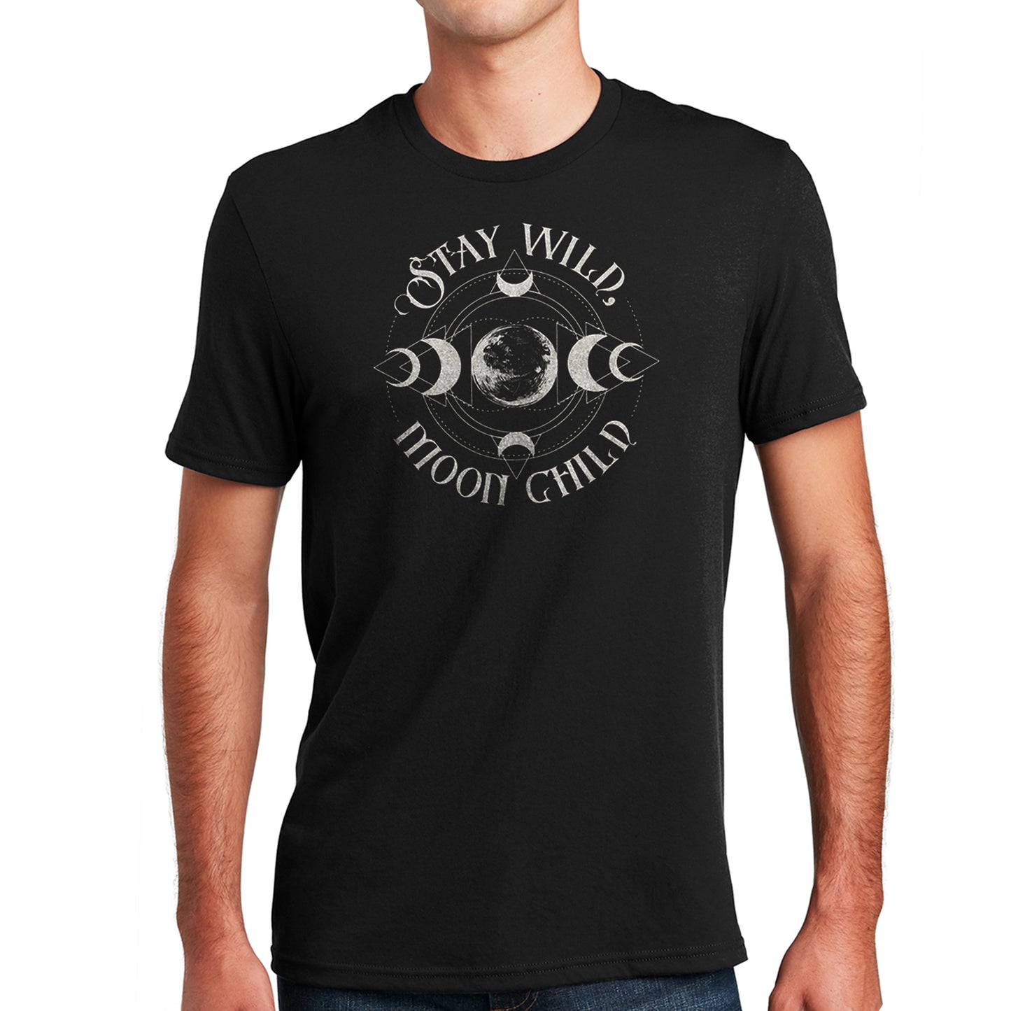 A male model wearing a black T-shirt with silver text saying "Stay Wild Moon Child." There is a depiction of the Moon in the center, with crescent Moon phases at top, bottom, left, and right of the center. There are thin circles around the moon phases, connecting them to each other.